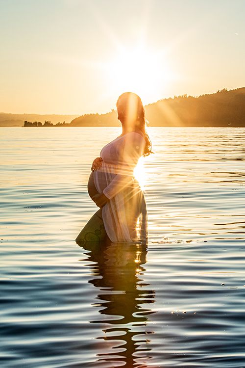 Schwangere Frau im sonnenuntergang